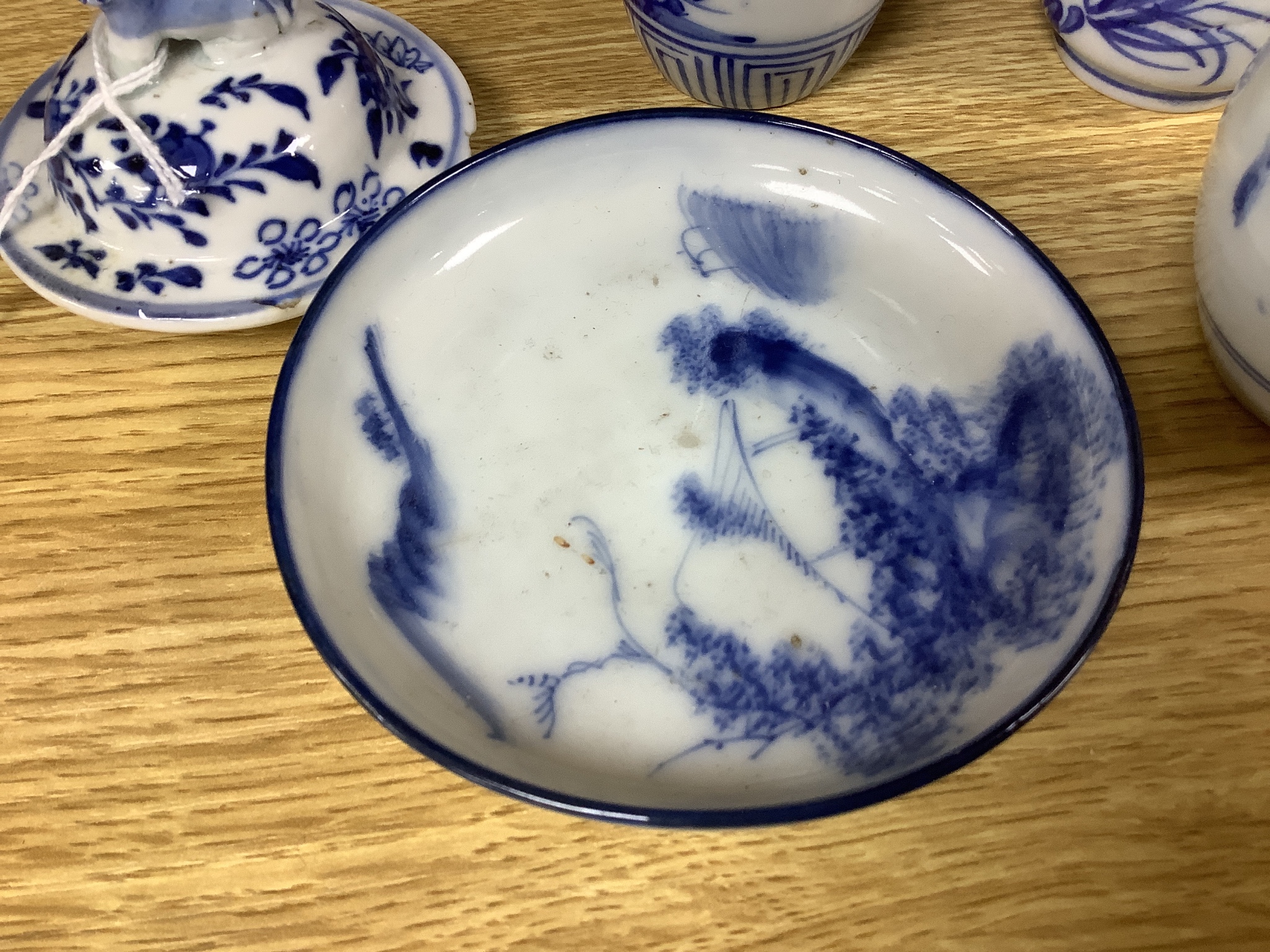 A pair of lidded Chinese blue and white vases, c.1900, Kangxi marks, 23cm high, together with two small Japanese vases, and a cup and saucer (6)
